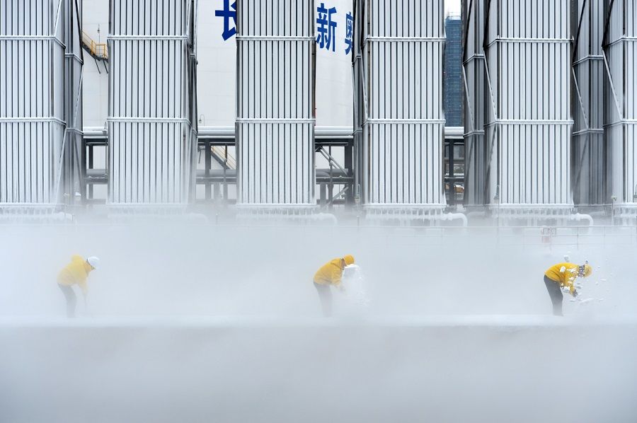 Workers remove snow at a liquefied natural gas (LNG) facility of ENN Group in Changsha, Hunan province, China, 31 December 2018. (Stringer/File Photo/Reuters)