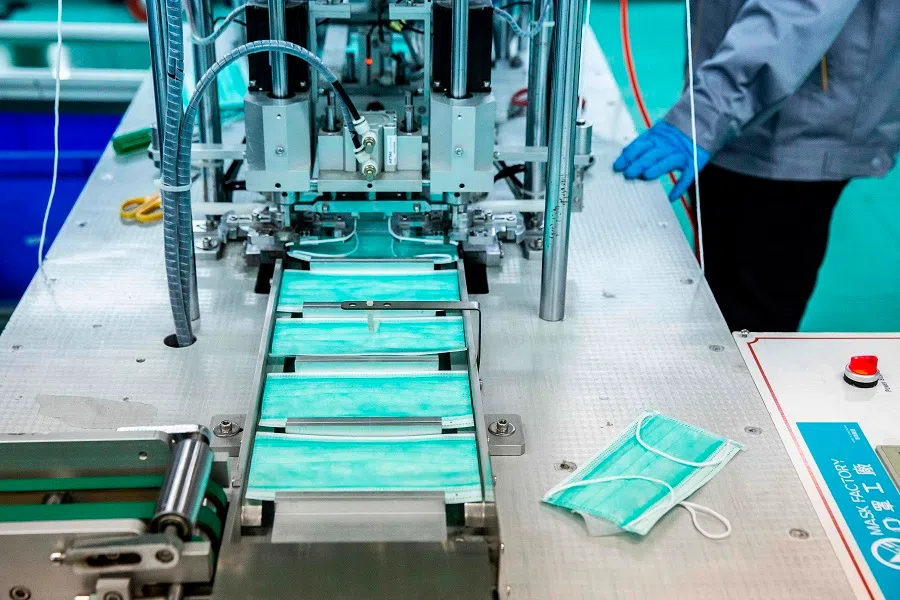This picture taken on 19 February 2020 shows a surgical mask factory in Hong Kong. Faced with shortages in the midst of a virus outbreak, Hong Kongers have started making their own face masks, from professional factories to seamstresses churning out coverings on sewing machines. (Isaac Lawrence/AFP)