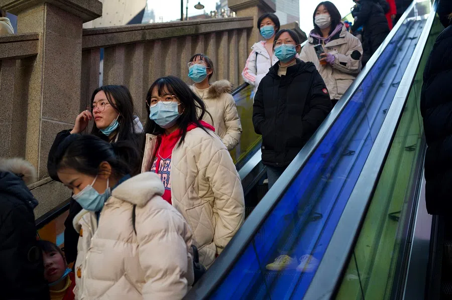People wearing face masks ride an escalator at a shopping centre in Wuhan, Hubei province, China, on 1 January 2021. (Noel Celis/AFP)