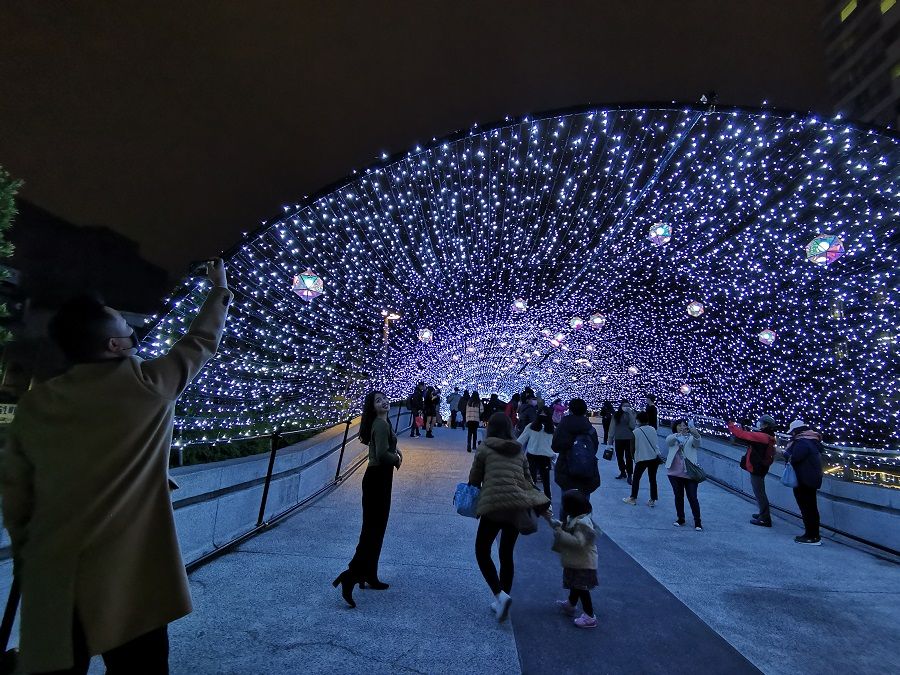 People walking under light decorations in Taiwan.