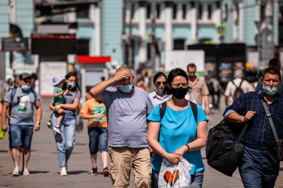 People wearing face masks walk down a street in Moscow, Russia on 21 June 2021. (Dimitar Dilkoff/AFP)