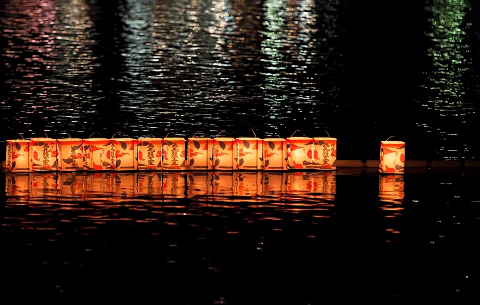 Lanterns with candles float on the waters of the Hozu River in Kyoto, Japan. The lanterns carry prayers to send off ancestors' spirits. (iStock)