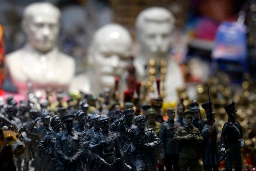 (Left to right) Busts of Russian President Vladimir Putin, the founder of the Soviet Union Vladimir Lenin and Soviet dictator Joseph Stalin sit behind miniature soldiers at a souvenir kiosk in Moscow on 12 October 2022. (Natalia Kolesnikova/AFP)