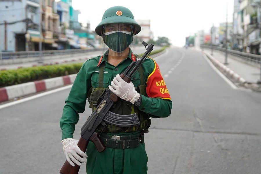 A Vietnamese military personnel stands guard on a deserted road in Ho Chi Minh City, Vietnam, on 23 August 2021. (Pham Tho/AFP)