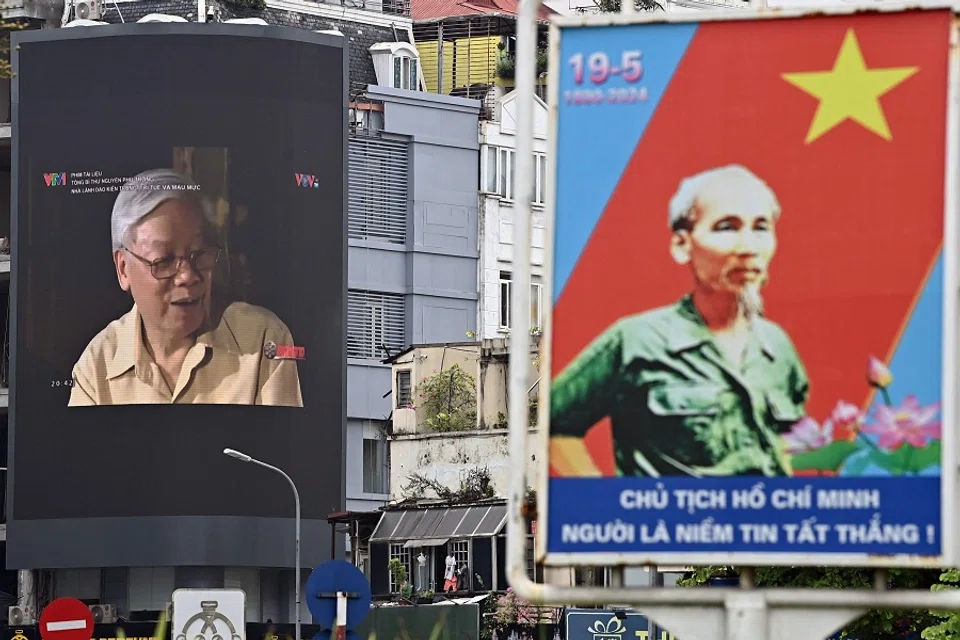 A large screen on a commercial building shows Nguyen Phu Trong (left), the late general secretary of the Communist Party of Vietnam, past a billboard showing late Vietnamese revolutionary leader Ho Chi Minh in Hanoi on 22 July 2024. (Nhac Nguyen/AFP)