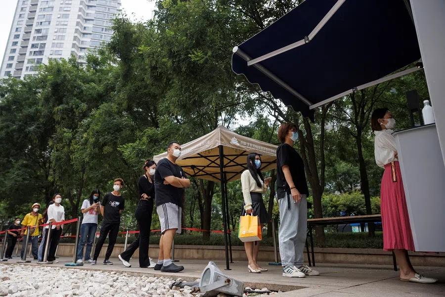 People line up to get a swab at a nucleic acid testing booth following a Covid-19 outbreak in Beijing, China, 13 September 2022. (Thomas Peter/Reuters)