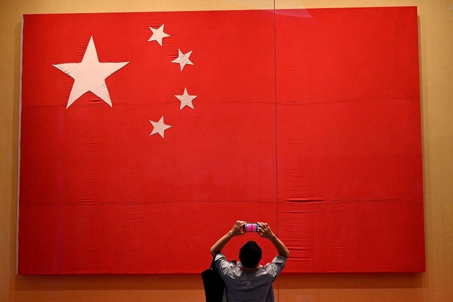 A journalist takes a picture of the national flag during a visit to the Museum of the Communist Party of China, in Beijing, China, on 25 June 2021. (Noel Celis/AFP)
