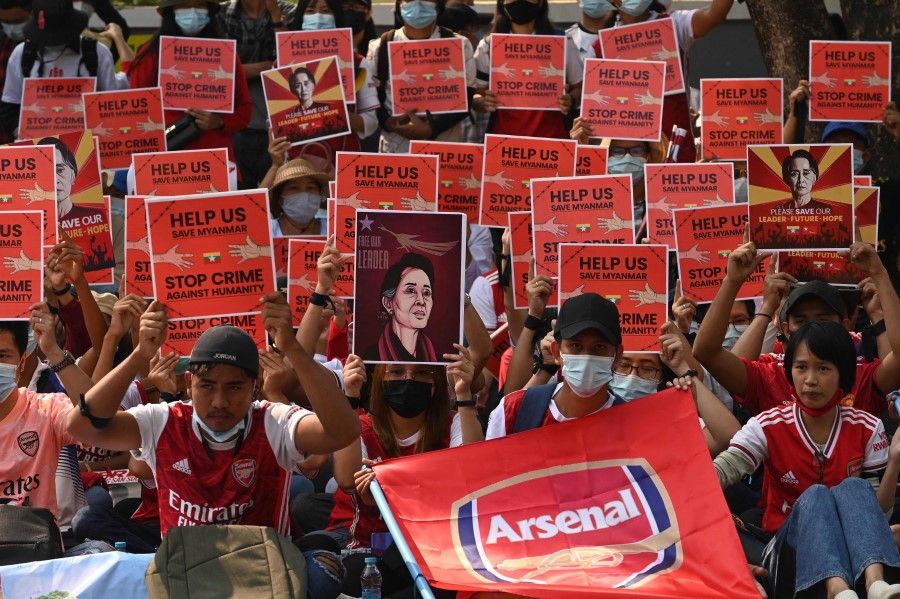 Protesters hold placards and display images of ousted civilian leader Aung San Suu Kyi as they take part in a demonstration against the military coup, in front of the Chinese embassy in Yangon on 21 February 2021. (Sai Aung Main/AFP)
