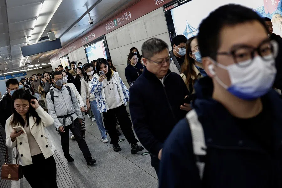 People walk at a subway station during morning rush hour in Beijing, China, on 11 April 2024. (Tingshu Wang/Reuters)