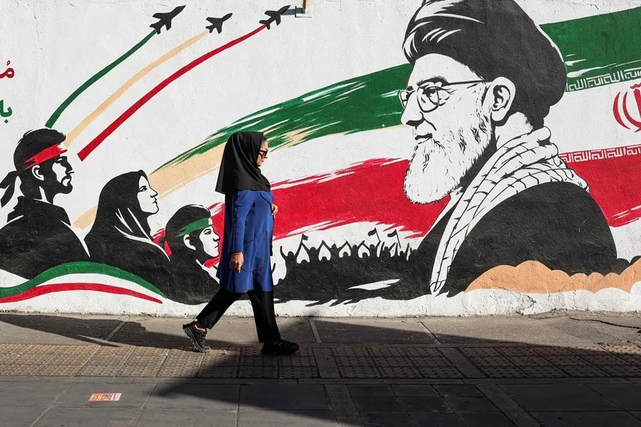 An Iranian woman walks past a mural of Iran's slain supreme leader Ayatollah Ali Khamenei in Tehran on 23 September 2026.
