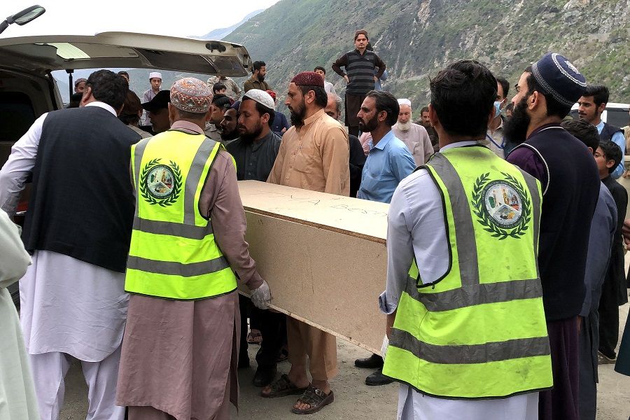 Volunteers transport the coffins of Chinese nationals from a hospital following a suicide attack in Besham city in the Shangla district of Khyber Pakhtunkhwa province, Pakistan, on 26 March 2024. (Omar Bacha/AFP)