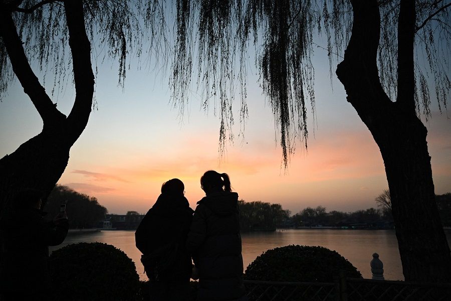People watch the sunset at Shichahai park in Beijing on 4 December 2023. (Jade Gao/AFP)