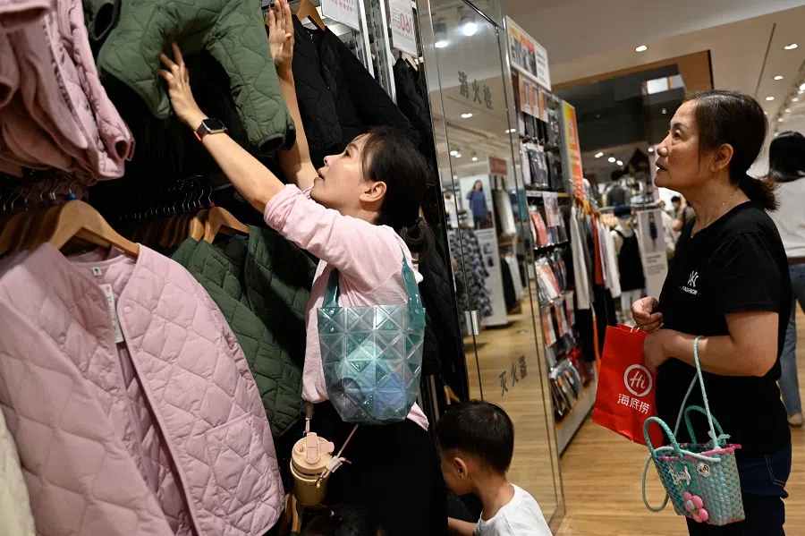 Shoppers browse through clothing for sale at a mall in Beijing, China, on 17 September 2023. (Pedro Pardo/AFP)