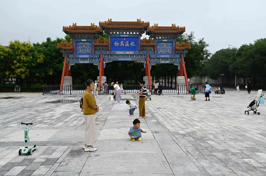 Local residents rest outside a temple near a residential area in Beijing on 21 August 2025.  (Wang Zhao/AFP)