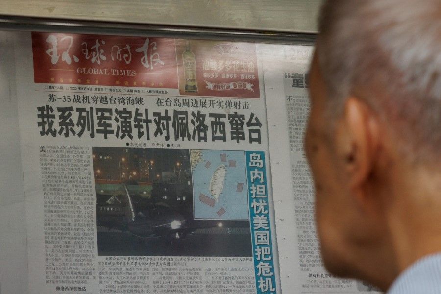 A man reads a Global Times article about military exercises by the Chinese People's Liberation Army (PLA) following US House of Representatives Speaker Nancy Pelosi's Taiwan visit, at a newspaper stand in Beijing, China, 4 August 2022. (Thomas Peter/Reuters)
