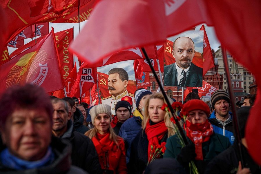 Russian Communist Party activists and supporters carry portraits of Soviet founder Vladimir Lenin (right) and Soviet dictator Joseph Stalin (left) as they attend a flowers-laying ceremony at the Lenin's Mausoleum on Red Square in downtown Moscow, Russia, on 7 November 2021, marking the 104th anniversary of the October Revolution. (Dimitar Dilkoff/AFP)