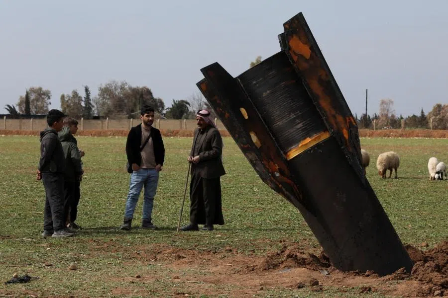 People stand next to an Iranian missile after it fell near Qamishli International Airport, amid the US-Israeli conflict with Iran, in Qamishli, Syria, on 4 March 2026. (Orhan Qereman/Reuters)