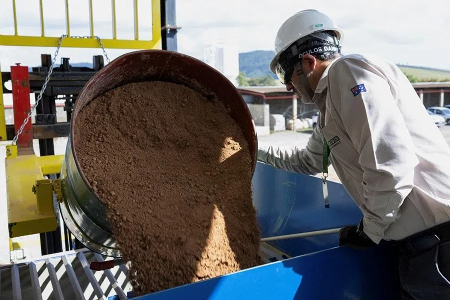 A worker handles a container of rare earth samples at the rare earth research and processing centre of Australian mining company Viridis Mining and Minerals in Pocos de Caldas, Brazil, 20 June 2026.