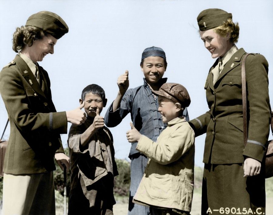 Three Chinese boys give the thumbs up to two members of the Women's Army Corps who have just arrived in China, 20 November 1944. One of the women courteously returns the gesture. The Women's Army Corps was formed in 1942, mainly for administrative, communications, and secretarial work, with about 150,000 American women serving in it during World War II. The first women to arrive in China in 1944 served in Chongqing headquarters, with over 280 female soldiers serving in the China-Burma-India Theatre in January 1945.