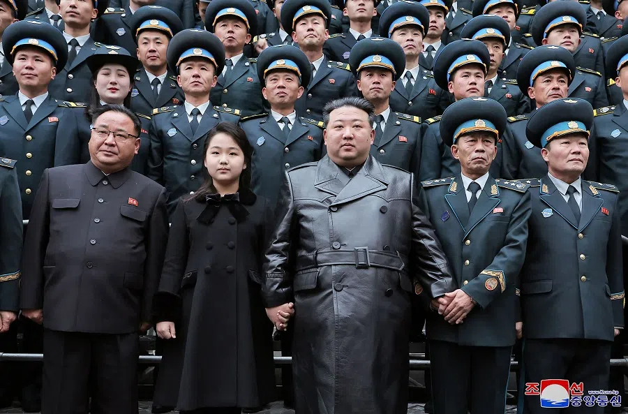 This picture taken on 23 November 2023 and released by North Korea's official Korean Central News Agency (KCNA) on 24 November 2023 shows North Korea's leader Kim Jong-un (centre) and his daughter (front row, second from left) posing with scientists who contributed to the launch of a reconnaissance satellite, at the National Aerospace Technology Directorate in Pyongyang. (KCNA via KNS/AFP)