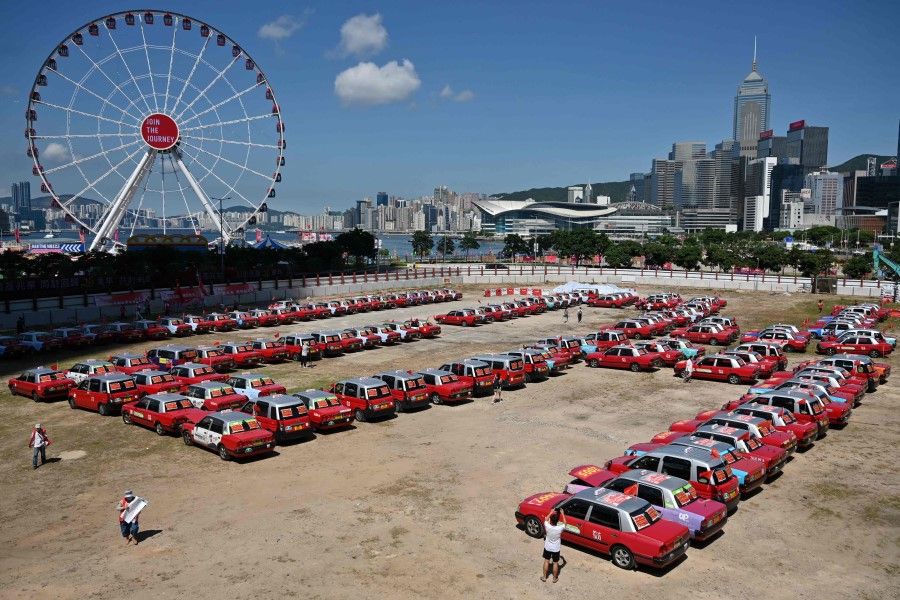 Taxi drivers park their vehicles forming the number 25 to mark the 25th anniversary of the Handover of Hong Kong from Britain to China, which falls on July 1, in the Central district of Hong Kong on 28 June 2022. (Peter Parks/AFP)