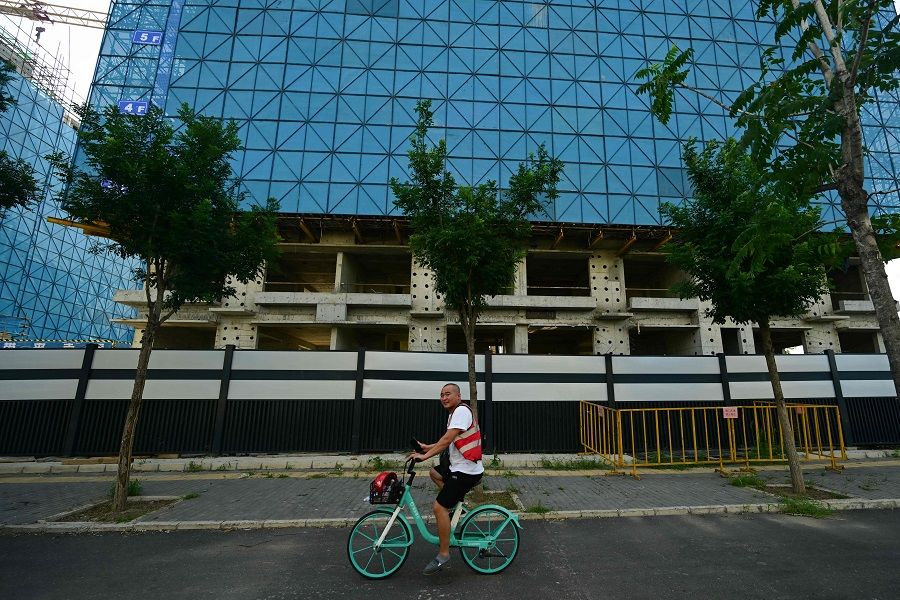 A man rides past a development of property developer Country Garden in Beijing, China, on 15 August 2023. (Pedro Pardo/AFP)