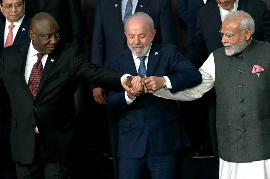 (left to right) South Africa’s President Cyril Ramaphosa, Brazil’s President Luiz Inacio Lula da Silva and India’s Prime Minister Narendra Modi hold hands as they pose for a family photo of heads of state and government of member, partner, and external engagement countries during the BRICS summit in Rio de Janeiro, Brazil, on 7 July 2025.