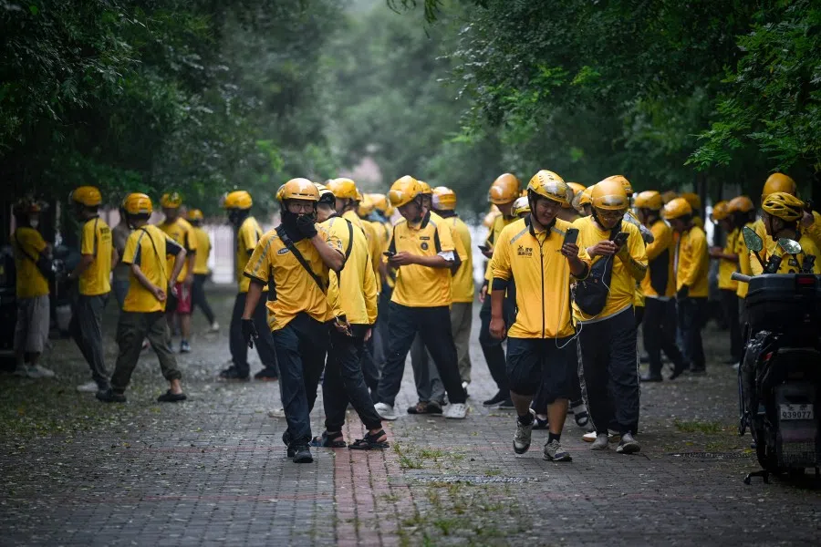 Deliverymen of Chinese shopping platform Meituan leave after a briefing before they start their shift near a mall in Beijing on 21 August 2025. (Wang Zhao/AFP)