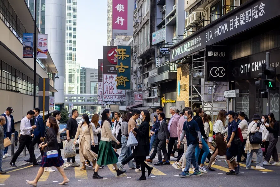Pedestrians cross a street in the Central district in Hong Kong, China, 20 November 2023.