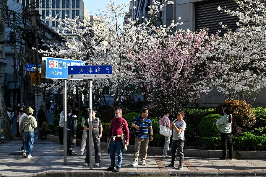 People walk on a street in the Huangpu district, in Shanghai on 30 March 2024. (Hector Retamal/AFP)