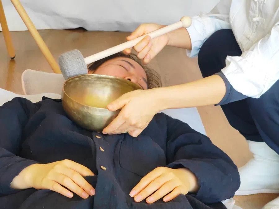A client undergoing singing bowl sound therapy at Yiyan natural therapy studio to help with insomnia and anxiety.
