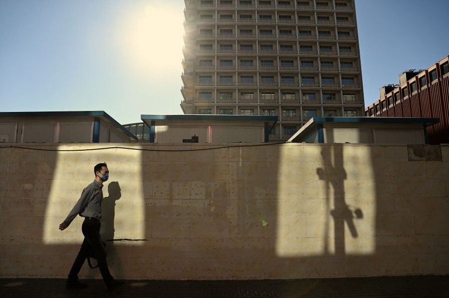 A man walks along a street in Beijing on 31 August 2022. (Noel Celis/AFP)