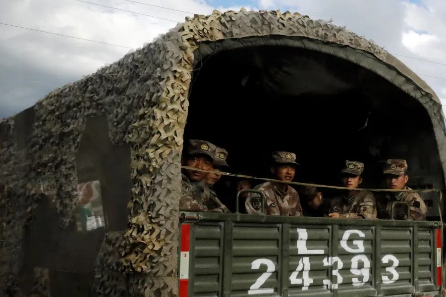 Chinese soldiers of the People's Liberation Army (PLA) sit on the back of a truck on the highway to Nyingchi, Tibet Autonomous Region, China, 19 October 2020. (Thomas Peter/REUTERS)