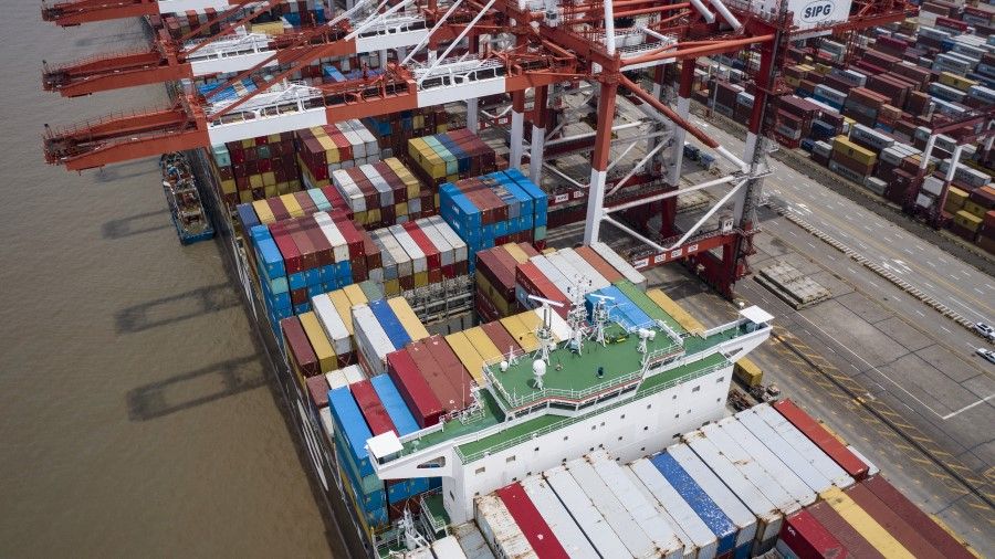 A vessel loaded with shipping containers is docked at the Yangshan Deepwater Port in this aerial photograph taken in Shanghai, China, on 12 July 2020. (Qilai Shen/Bloomberg)