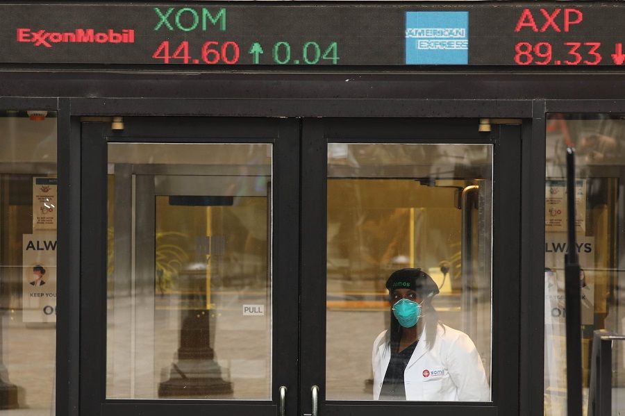 A medical worker stands at the entrance to the New York Stock Exchange on the first day that traders are allowed back onto the historic floor of the exchange on 26 May 2020 in New York City. (Spencer Platt/Getty Images/AFP)
