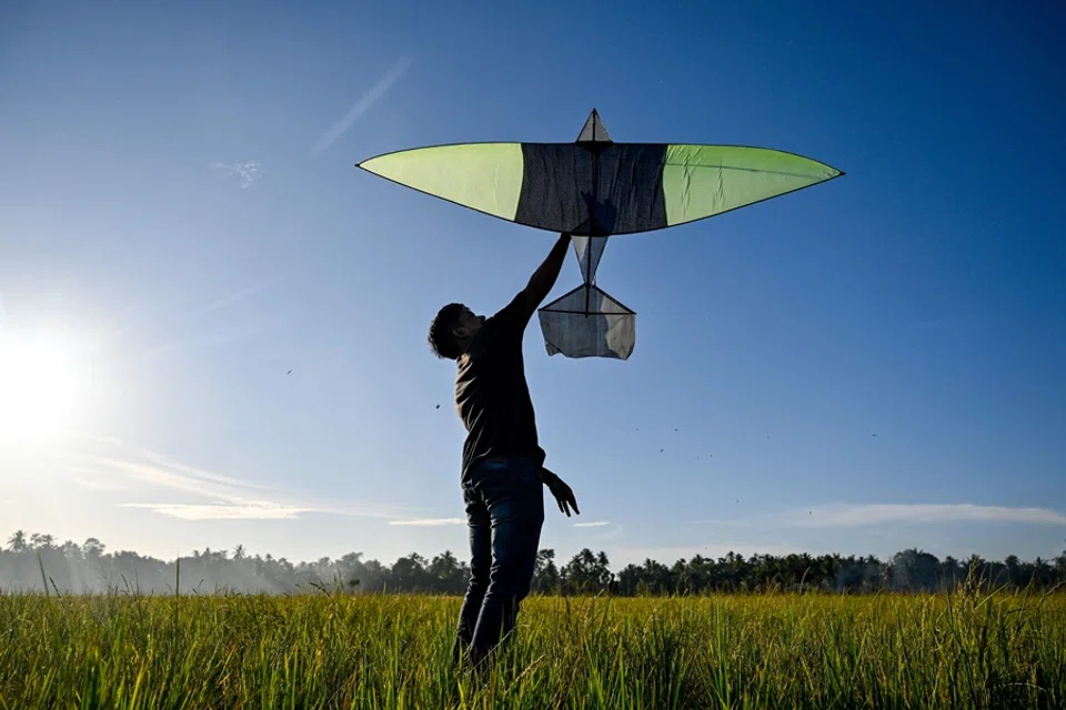 A villager flies a kite as part of a tradition after the paddy harvest in Aneuk Galong, Aceh province, Indonesia, on 19 September 2025. (Chaideer Mahyuddin/AFP)