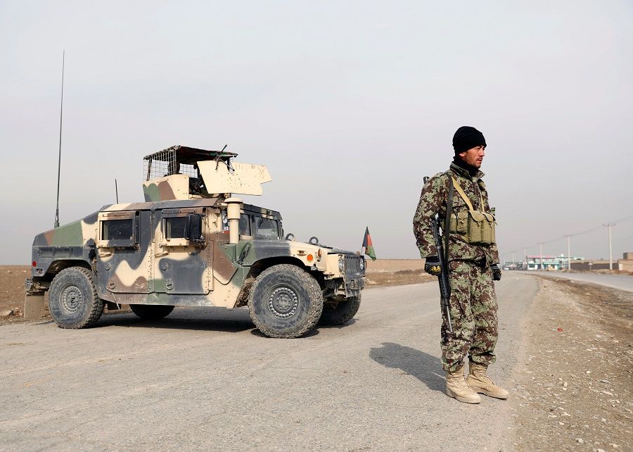 An Afghan National Army (ANA) soldier stands guard at a checkpoint on the outskirts of Kabul, Afghanistan, 18 November 2020. (Mohammad Ismail/Reuters)