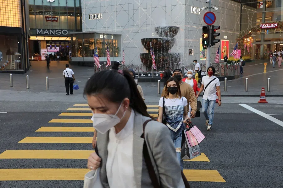 People wearing protective masks cross a street outside a shopping mall in Kuala Lumpur, Malaysia, 6 September 2021. (Lim Huey Teng/Reuters)