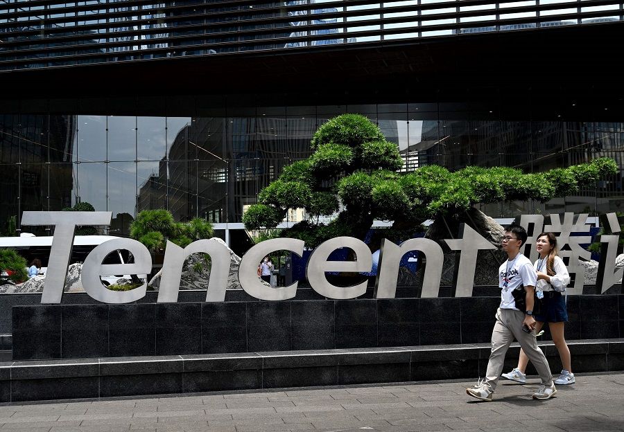 This file photo taken on 28 May 2021 shows people walking past the Tencent headquarters in Shenzhen, Guangdong province, China. (Noel Celis/AFP)