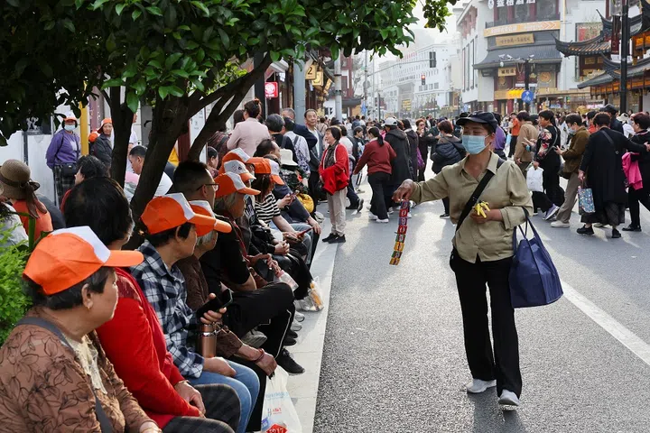 A street merchant tries to sell toys to visitors outside Yuyuan Garden in Shanghai, China, on 16 April 2025. (Go Nakamura/Reuters)