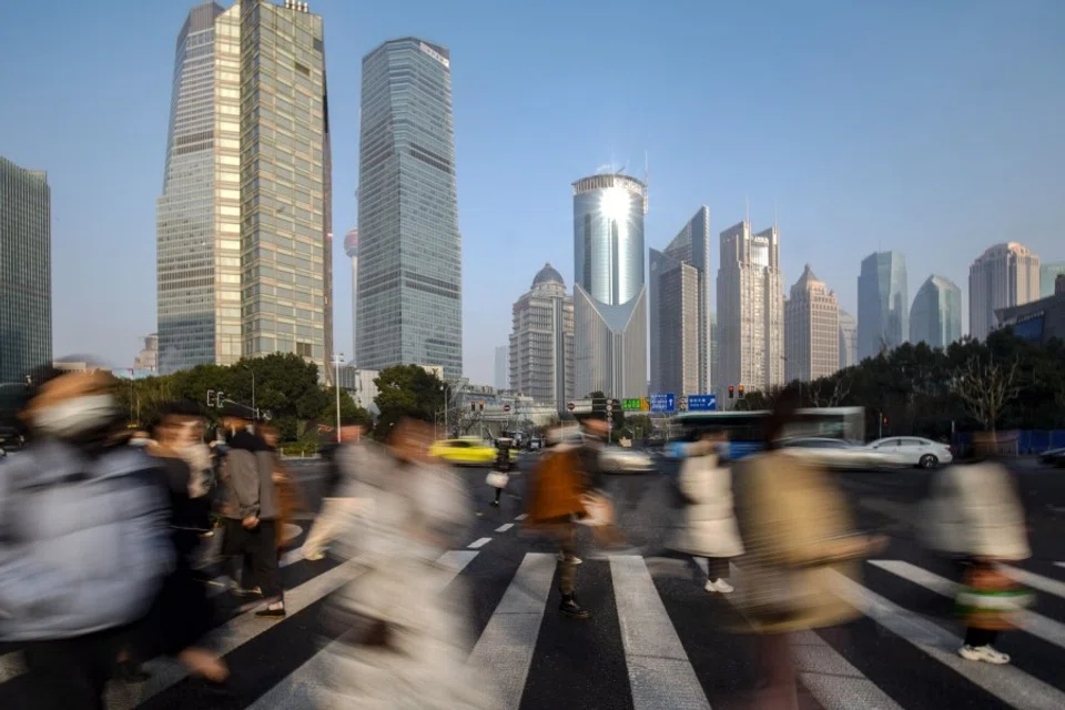 Pedestrians cross a road in Pudong's Lujiazui Financial District in Shanghai, China, on 9 January 2024. (Qilai Shen/Bloomberg)