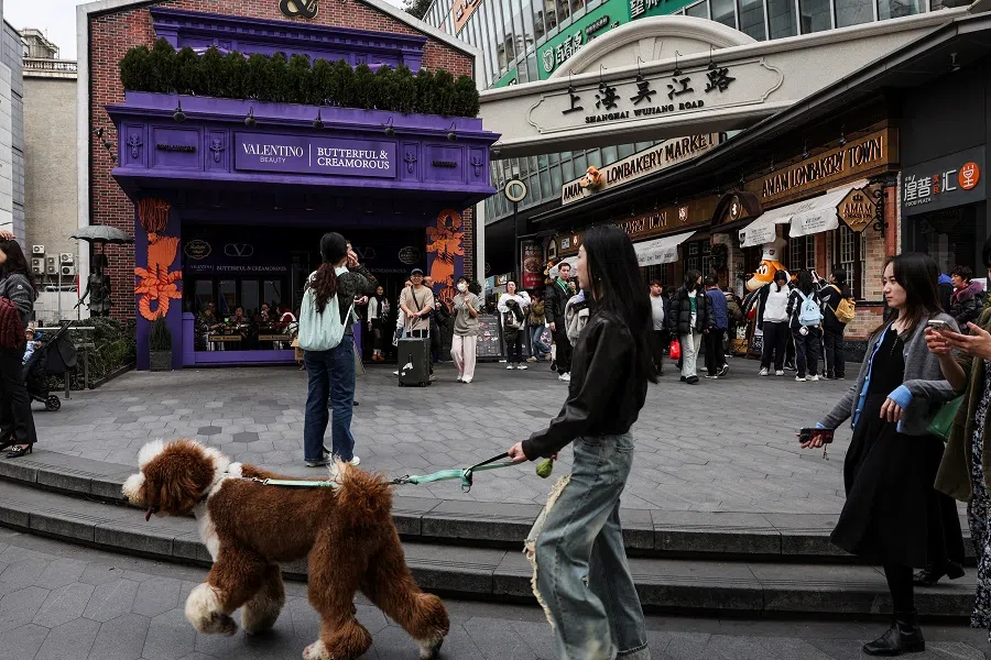 People walk at the entrance of Wujiang Road in Shanghai, China, on 28 February 2025. (Go Nakamura/Reuters)
