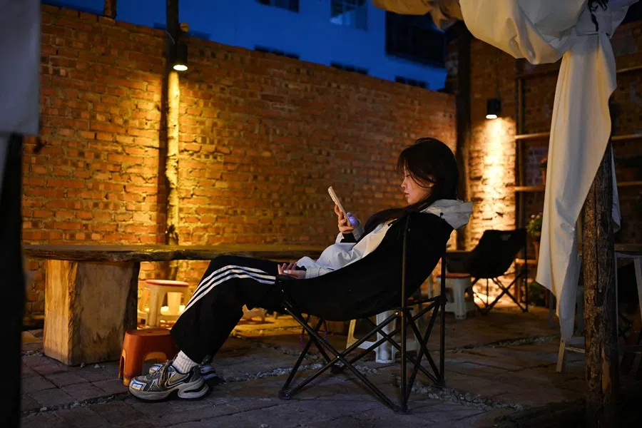This photo taken on 2 April 2025 shows a woman relaxing at a “youth retirement home” in Dali, in China’s southwestern Yunnan province.  (Greg Baker/AFP)
