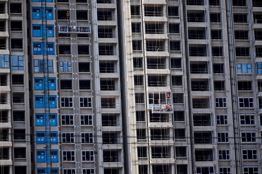 Workers install windows for residential buildings under construction, in Shanghai, China, 10 October 2022. (Aly Song/File Photo/Reuters)