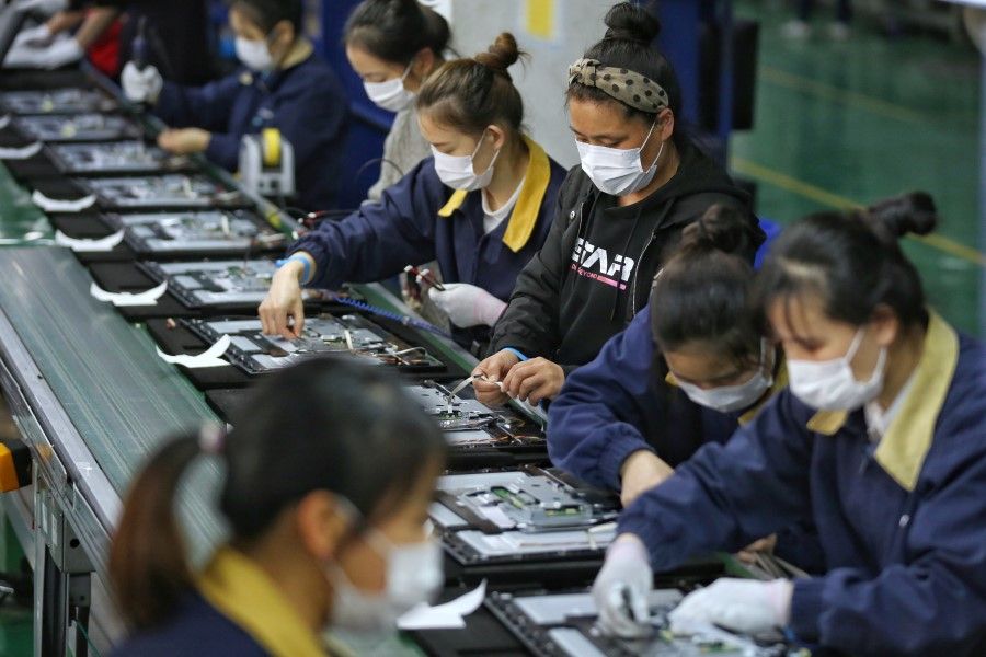 Employees work on a production line manufacturing display monitors at a TPV factory in Wuhan, April 7, 2020. (China Daily via REUTERS)