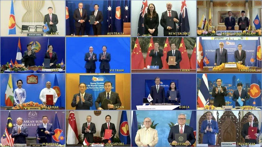 The Asean secretary-general and leaders of the 15 RCEP member countries with their trade ministers after the pact was signed on 15 Nov 2020. Each country's trade minister took turns signing a copy of the agreement, with proceedings broadcast to all via video link. (Ministry of Communications and Information, Singapore)