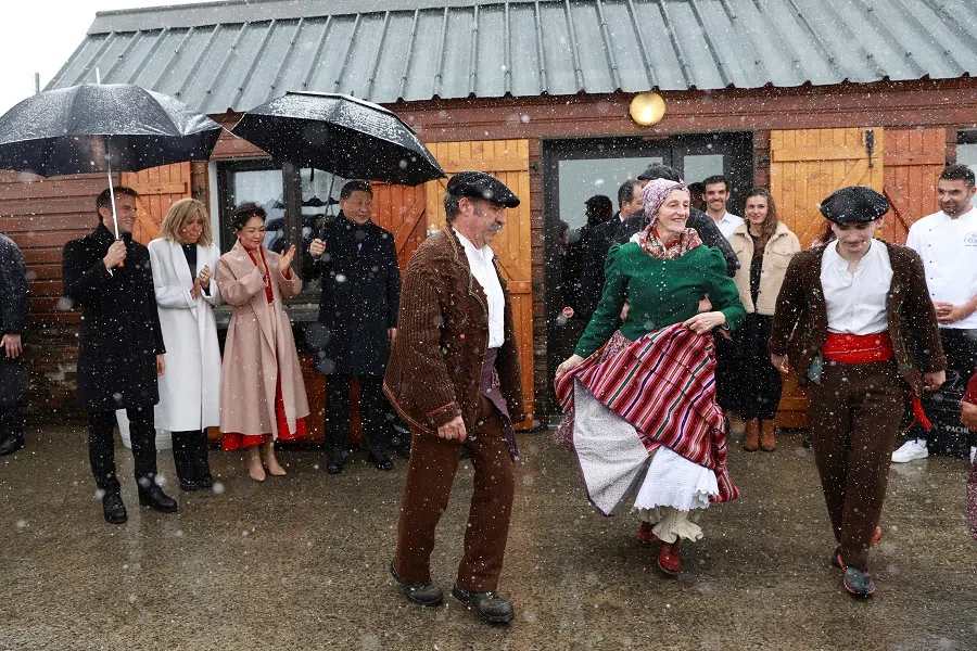 French President Emmanuel Macron and his wife Brigitte Macron, Chinese President Xi Jinping, and his wife Peng Liyuan watch folklore dancers on 7 May 2024 at the Tourmalet pass, in the Pyrenees mountains.  (Aurelien Morissard/Reuters)