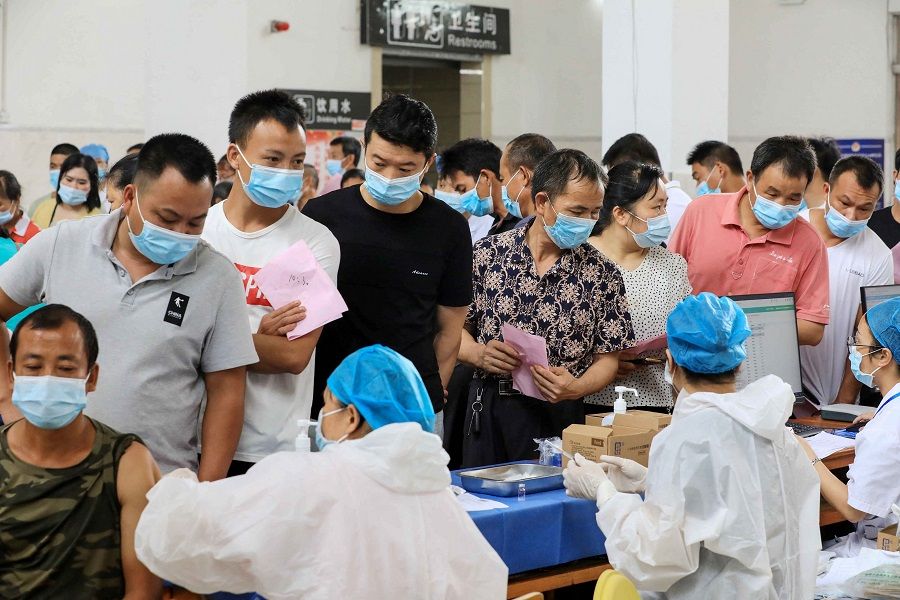 This photo taken on 3 June 2021 shows residents queueing to receive the Sinovac Covid-19 coronavirus vaccine in Rong'an, Guangxi, China. (STR/AFP)