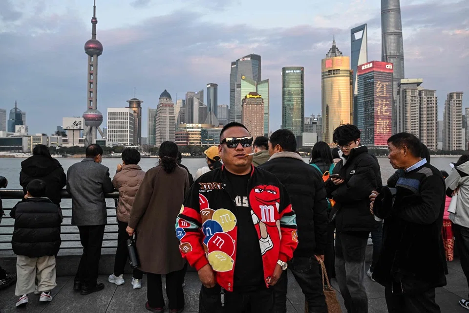 A man poses for a picture while visiting the Bund promenade along the Huangpu river in Shanghai, China, on 13 February 2024. (Hector Retamal/AFP)