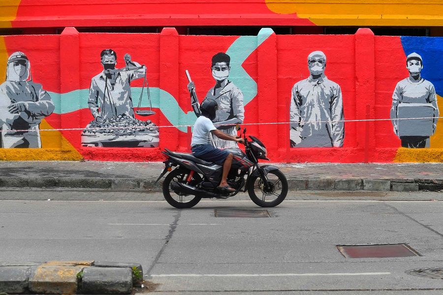 A motorist drives past a wall mural painted to thank frontline workers fighting against the Covid-19 coronavirus, in Mumbai, on 15 June 2020. (Indranil Mukherjee/AFP)